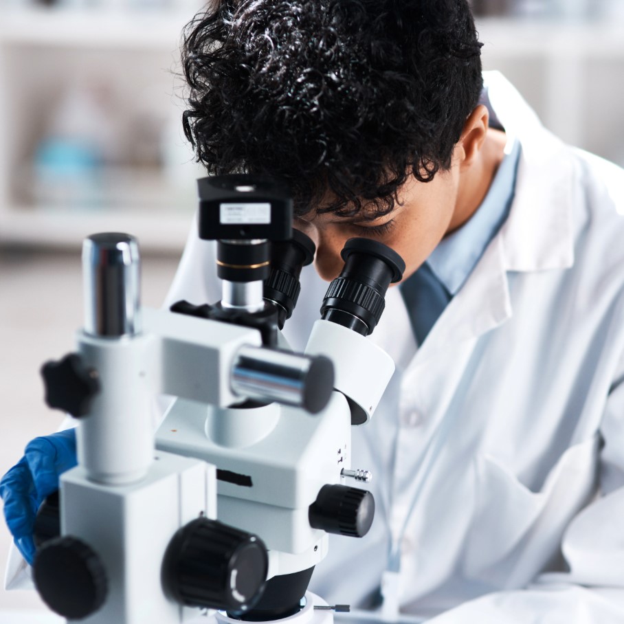 female scientist analyzing under microscope